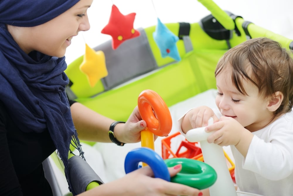 Arabic Muslim mother playing and taking care of her baby