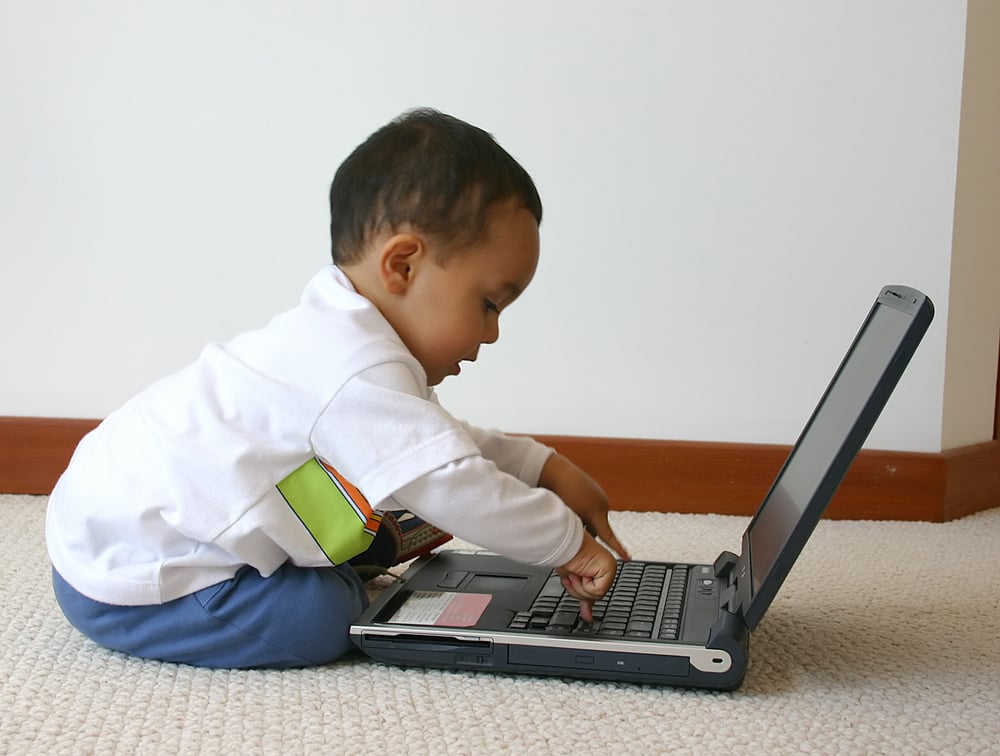 little boy playing with a laptop