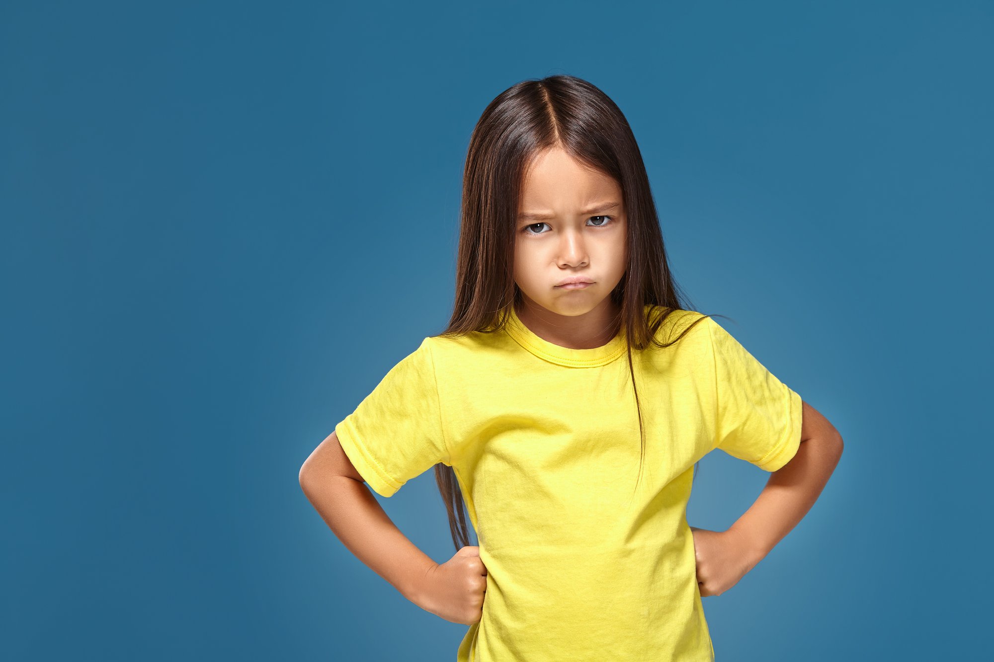 angry-little-kid-showing-frustration-disagreement-blue-background